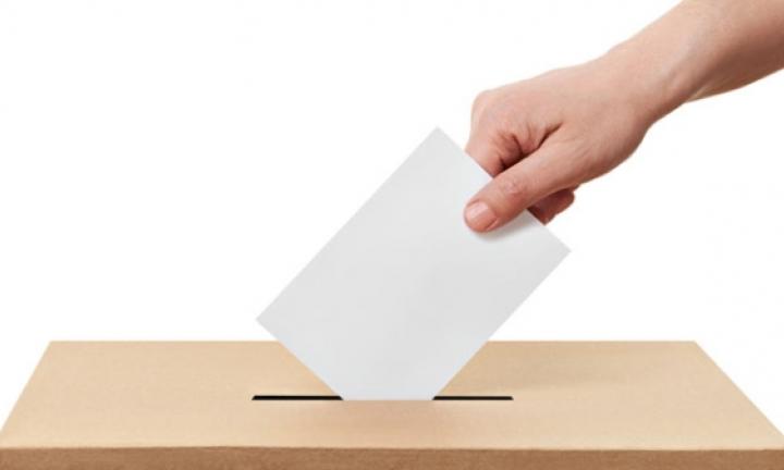 Mão a colocar voto na urna