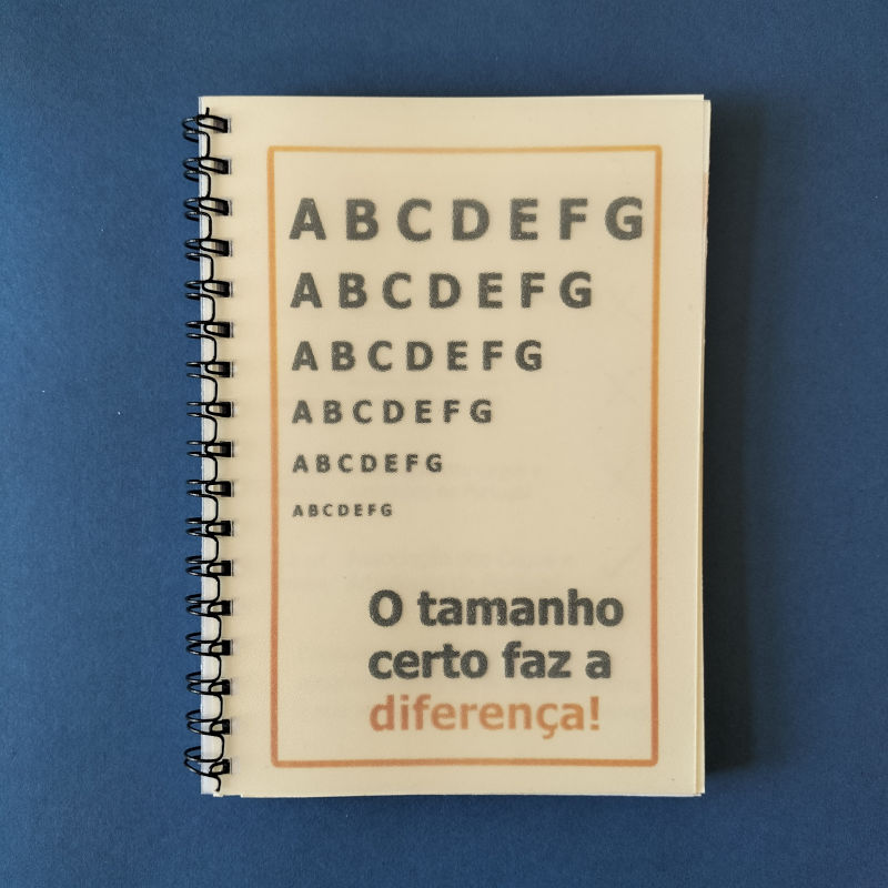 Capa do caderno onde é possível ver-se seis linhas com as letras de A a G. Da primeira à sexta linha o tamanho das letras vai diminuindo. Por baixo, a frase: O tamanho certo faz a diferença!