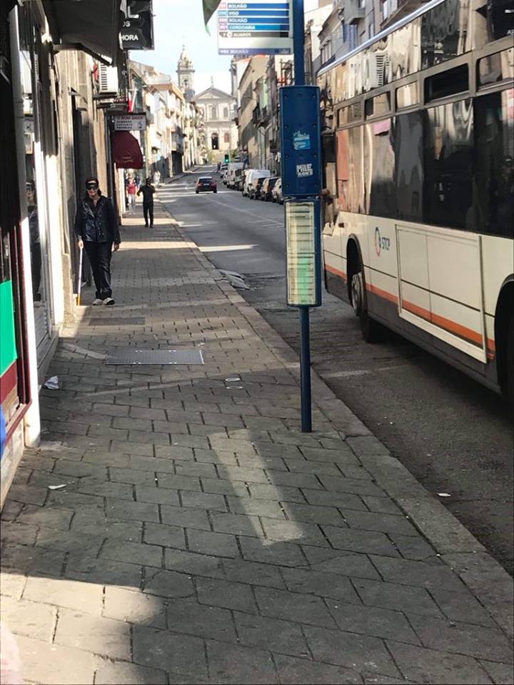 Pessoa de olhos vendados a andar de bengala no passeio