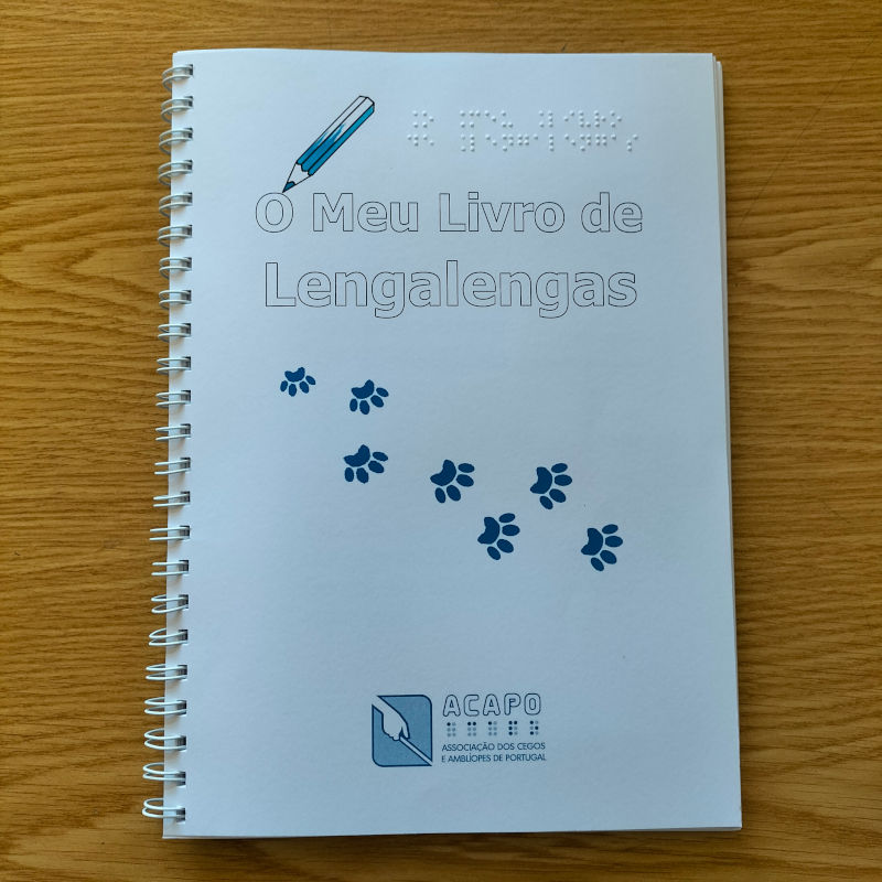 Título do livro e o desenho de um lápis de cor por cima, indicando que as crianças podem pintar o título. Por baixo, o desenho das pegadas deixadas pelas patas de um gato.