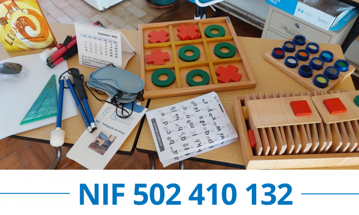 Fotografia de uma mesa onde estão diversos artigos relacionados com a deficiência visual, nomeadamente jogos adaptados, folhetos informativos, alfabetos Braille, bengalas, etc. Por baixo, em azul, o NIF 502410132.