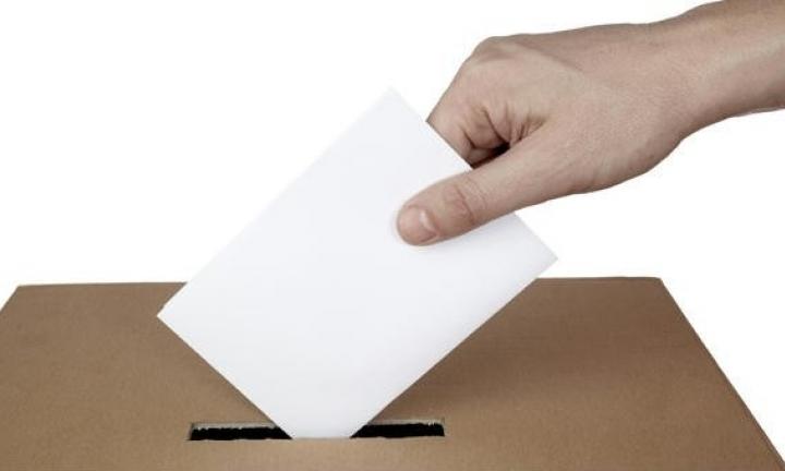 Mão a colocar voto na urna