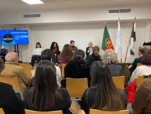 Sentados, Marta Vitorino, Tânia Gil, Elmano Sancho e Carlos Alves. Carlos Alves segura o microfone. Ao lado deles vê-se um ecrã com a projeção do logotipo das Caves Messias.