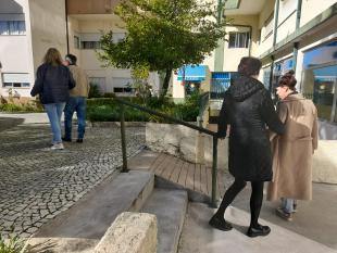 Duas duplas de participantes durante a experimentação das técnicas de guia. Em cada dupla, um dos participantes está de olhos vendados enquanto o parceiro o guia.