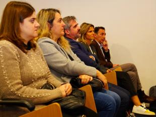 Palestrantes sentados na primeira fila