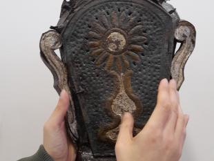 Mãos de um participante a tatear uma das peças em exposição no museu