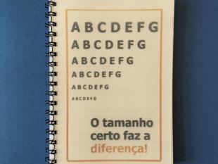 Capa do caderno onde é possível ver-se seis linhas com as letras de A a G. Da primeira à sexta linha o tamanho das letras vai diminuindo. Por baixo, a frase: O tamanho certo faz a diferença!