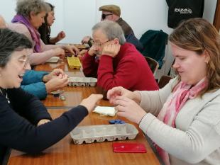 Três duplas de participantes a jogar com os protótipos do Ludusfidelis, elaborados com materiais reciclados – caixas de ovos e tampas ou caricas, e com numeração em Braille