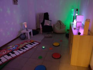 Fotografia da sala de estimulação onde é possível ver-se alguns dos materiais existentes, nomeadamente artigos de projeção de luz e de produção de sons.