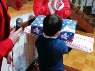 Paula Costa, Presidente da Direção da Delegação do Porto, com o Pai Natal da ACAPO e um menino com dois presentes na mão