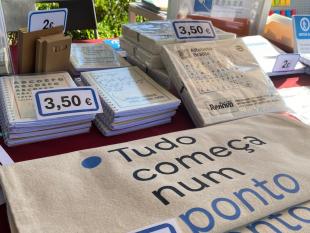 Fotografia da banca vendo-se alguns dos nossos artigos solidários, nomeadamente os tote bags, os cadernos de notas e os guardanapos.