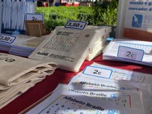 Fotografia da banca vendo-se alguns dos nossos artigos solidários, nomeadamente os panos para limpar óculos, os cadernos de notas, os guardanapos e as canetas.