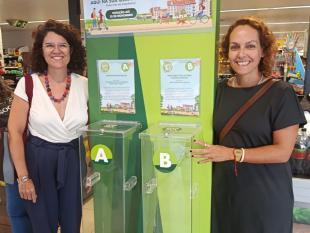 Joana Afonso, Técnica de Reabilitação da Delegação do Algarve, pousa sorridente para a fotografia junto aos mealheiros do Bairro Feliz. Ao seu lado está uma representante da Associação de Pais EB1 S. Luis, entidade responsável pela outra causa a concurso.