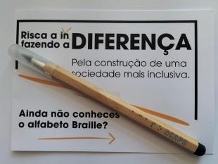 Lápis Infinito 3 Funções ACAPO preso no postal alusivo à Deficiência Visual - Risca a indiferença, fazendo a diferença. Pela construção de uma sociedade mais inclusiva. Ainda não conheces o alfabeto Braille?