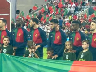 Crianças e jogadores da Seleção Nacional no relvado.