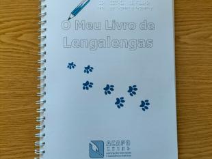 Título do livro e o desenho de um lápis de cor por cima, indicando que as crianças podem pintar o título. Por baixo, o desenho das pegadas deixadas pelas patas de um gato.