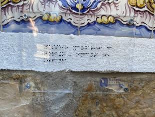 Fotografia ampliada da placa toponímica, em tinta e Braille, colocada junto ao Palácio Estoril Hotel.