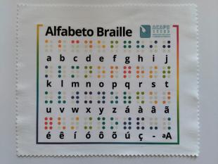 Pano de limpeza de óculos da ACAPO em cima de uma mesa.