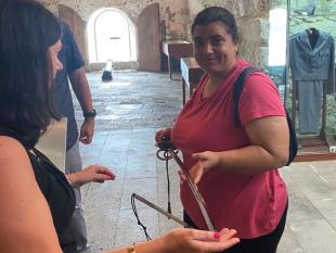 Uma Associada segura na mão uma espada do Museu.